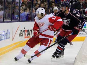 Detroit's Patrick Eaves, left, and Columbus' Adrian Aucoin battle for the puck during NHL hockey action Monday, Jan. 21, 2013, in Columbus, Ohio. (AP Photo/Jay LaPrete)