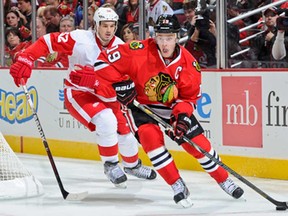 Chicago's Jonathan Toews, right, takes the puck around the net as Detroit's Jonathan Ericsson chases during NHL action January 27, 2013 at the United Center in Chicago. (Bill Smith/NHLI via Getty Images)