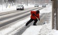 Windsor resident Peter Gerard takes on snow around a bus stop on Riverside Drive East near Solidarity Towers on Feb. 8, 2013. (Nick Brancaccio / The Windsor Star)