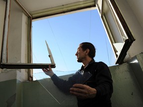 A resident of Chelyabinsk, about 1500 kilometres east of Moscow, repairs a window broken by a shock wave from a meteor explosion, Friday, Feb. 15, 2013. A meteor that scientists estimate weighed 10 tons streaked at supersonic speed over Russia's Ural Mountains on Friday, setting off blasts that injured some 1,000 people. (AP Photo/Boris Kaulin)