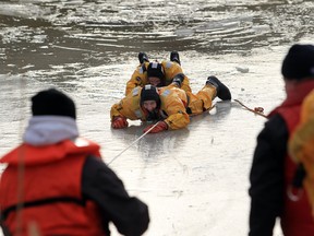 Amherstburg firefighters Bill Scott and Mario Fiorito take part in a water rescue exercise in the Rivere Canard on Saturday Feb. 16, 2013 in Amherstburg.   Windsor-Essex EMS,  Tecumseh Fire Service and Amherstburg Fire Service participated in the annual training to familiarize the first responders with ice and water rescue operations.  (JASON KRYK/ The Windsor Star)