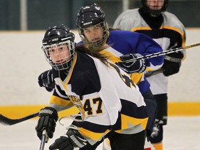 St. Joseph's Hannah Laroque, left, and St. Anne's Amy Maitre battle for the puck Tuesday at Tecumseh Arena. (DAN JANISSE/The Windsor Star)