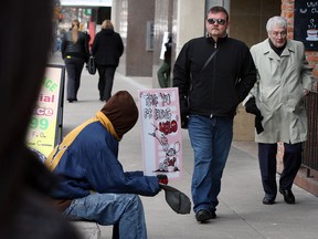 Ouellette Avenue panhandlers known as Sign Man, asks for donations as Mike Holdsworth, centre, president of Downtown Residents Association tours the area Friday February 15, 2013.  (NICK BRANCACCIO/The Windsor Star)