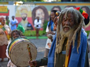 A Rastafarian priest leads a chant during the celebration of reggae music icon Bob Marley's 68th birthday in the yard of his Kingston home, in Jamaica, Wednesday, Feb. 6, 2013. Marley's relatives and old friends were joined by hundreds of tourists to dance and chant to the pounding of drums to honor the late reggae icon who died of cancer in 1981 at age 36. (AP Photo/ David McFadden)