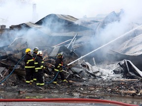 Firefighters hose down a fire at a cheese factory in St. Albert, Ontario east of Ottawa, Sunday, Feb. 3, 2013. A cheese factory east of Ottawa known for its poutine-topping curds has been gutted by a fire that broke out this morning.THE CANADIAN PRESS/Fred Chartrand