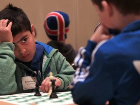 Adam Salloum from Monseigneur-Jean-Noel, left, looks up at his chess opponent  Alex Brule from Pavillon des Jeunes during the 2013 Windsor Chess Challenge at the Ciociaro Club in Tecumseh, Ontario on February 26, 2013.  More than 1000 students will take part in the two-day event. (JASON KRYK/The Windsor Star)