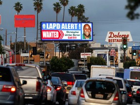 A digital billboard along Santa Monica Boulevard on the west side of Los Angeles shows a "wanted" alert for former Los Angeles police officer Christopher Dorner Friday, Feb. 8, 2013. Dorner is suspected in a spree of violence as part of a vendetta against law enforcement after being fired by the department. He is also a suspect in the shooting deaths of a former LAPD captain's daughter and her fiance, and two other shootings that left an officer dead and two others wounded. (AP Photo/Reed Saxon)