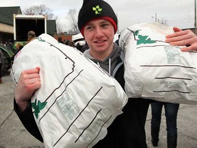 Essex District High School student Mitch Hudvagner shows his strength by carrying two sacks of potatoes from C.J. Bradley and Sons during United Communities Credit Union Farms to Food Banks program at United Communities Credit Union on Talbot Street in Essex, February 21, 2013. (NICK BRANCACCIO/The Windsor Star)