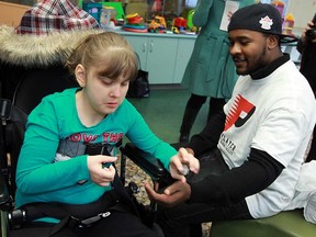 Megan Bryksa gets a close look at the Toronto Argonauts Walter Spencer when he brought the Grey Cup to Windsor Regional Hospital in Windsor on Tuesday, February 5, 2013. (TYLER BROWNBRIDGE / The Windsor Star)