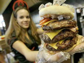 Waitress Courtney Chapman holds up a triple bypass burger at the Heart Attack Grill in Las Vegas. (Photograph by: Matt York , AP file photo)