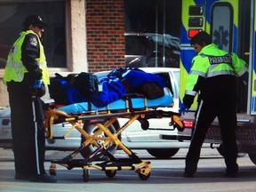 Paramedics transport a woman to hospital after she was struck by a car on Howard Avenue near Edinborough Street. (Jason Kryk/The Windsor Star)