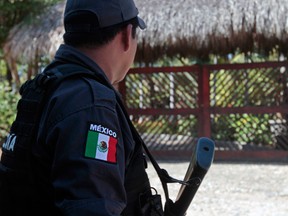 Policemen of Guerrero State stand guard on February 5, 2013 outside of the house where six Spanish women tourists were raped by masked gunmen on the eve, in Barra Vieja, a resort in Acapulco, Guerrero state. Acapulco mayor Luis Walton Aburto said in a briefing that the group of tourists was attacked outside a house in Barra Vieja, and that hooded gunmen raped the six women who were with another seven Spaniards as well as a Mexican woman. AFP PHOTO/Pedro Pardo