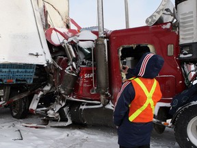 Emergency crews and tow trucks work on clearing some of the approximately 50 vehicles involved in a chain reaction collision on the eastbound 401 highway near, Ingersol, Ont., Friday, February 1, 2013. THE CANADIAN PRESS/Dave Chidley