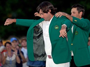 In this April 8, 2012 file photo, Charl Schwartzel, right, of South Africa, helps Bubba Watson put on the green jacket after winning the Masters golf tournament in Augusta, Ga. There's one palm tree at Augusta National, and it takes on new meaning for Masters champion Bubba Watson. (AP Photo/David J. Phillip, File)