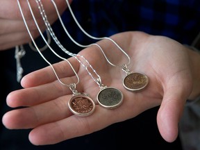 Renee Gruszecki displays jewelry she designs from coins at her studio, Coin Coin designs & co., in Halifax on Saturday, Feb. 2, 2013. Many of Gruszecki's personalized creations feature the Canadian one cent coin which has been phased out by the federal government in a cost-saving move. THE CANADIAN PRESS/Andrew Vaughan