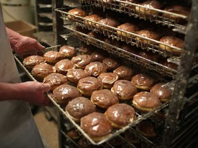 Daniel Gill pulls out a tray of freshly glazed Paczkis at Blak's Bakery, Monday, February 11, 2013.  (DAX MELMER/The Windsor Star)