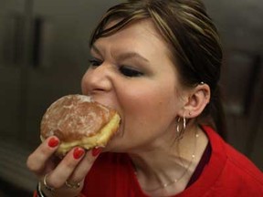 Jen Masselis, 28, bites into a fresh Nutella filled paczki at Blak's Bakery, Monday, February 11, 2013.  (DAX MELMER/The Windsor Star)