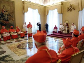 In this photo provided by the Vatican newspaper L'Osservatore Romano, Pope Benedict XVI, sitting on the throne at center-right, attends a meeting of Vatican cardinals, at the Vatican, Monday, Feb. 11, 2013. Benedict XVI announced Monday that he would resign Feb. 28 - the first pontiff to do so in nearly 600 years. The decision sets the stage for a conclave to elect a new pope before the end of March. (AP Photo/L'Osservatore Romano, ho)