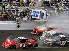 Kyle Larson (32) goes airborne into the catch fence in a multi-car crash including Dale Earnhardt Jr. (88), Parker Kligerman (77), Justin Allgaier (31) and Brian Scott (2) during the final lap of the NASCAR Nationwide Series auto race at Daytona International Speedway, Saturday, Feb. 23, 2013, in Daytona Beach, Fla. (AP Photo/John Raoux)