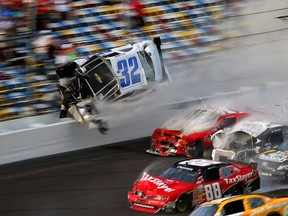 Kyle Larson (32) goes airborne before catching the fencing, in a wreck including Dale Earnhardt Jr. (88), Parker Kligerman (77), Justin Allgaier (31) and Brian Scott (2) during the final lap of the NASCAR Nationwide Series auto race at Daytona International Speedway, Saturday, Feb. 23, 2013, in Daytona Beach, Fla. (AP Photo/John Moore)