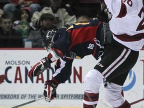 Windsor's Graeme Brown, left, takes a fall next to Guelph's Justin Auger as the Windsor Spitfires host the Guelph Storm at the WFCU Centre, Sunday, February 3, 2013.  Guelph won 6-3.  (DAX MELMER/The Windsor Star)