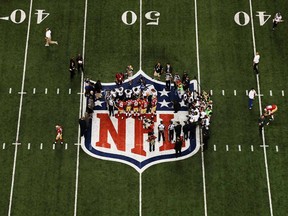 Players from the San Francisco 49ers and the Baltimore Ravens stand on the NFL logo for the opening coin toss during Super Bowl XLVII at the Mercedes-Benz Superdome on February 3, 2013 in New Orleans, La.  (Photo by Chris Graythen/Getty Images)