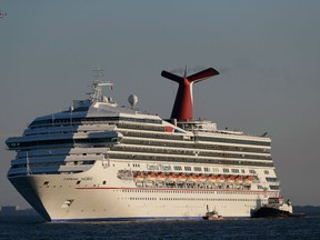 In this Feb. 14, 2013 file photo the cruise ship Carnival Triumph is towed into Mobile Bay near Dauphin Island, Ala., Thursday, Feb. 14, 2013. A leak in a fuel oil return line caused the engine-room fire that disabled a Carnival cruise ship at sea, leaving 4,200 people without power or working toilets for five days, a Coast Guard official said Monday, Feb. 18, 2013. (AP Photo/Dave Martin, File)
