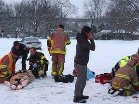 Paramedics and firefighters tend to two pedestrians that were struck by a car that lost control on Sandwich Street in Windsor, Ont. on Monday, Feb. 4, 2013. The accident occurred at approximately 6 p.m. just west of the Ambassador Bridge.  (DAN JANISSE/The Windsor Star)