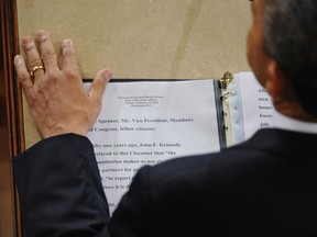 US President Barack Obama rests his hand next to a copy of his speech as he delivers his State of the Union address before a joint session of Congress on February 12, 2013 at the US Capitol in Washington, DC. AFP PHOTO/Mandel NGAN