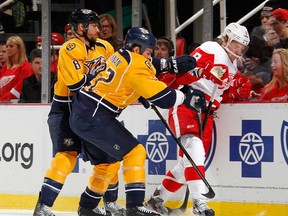 Justin Abdelkader #8 of the Detroit Red Wings tries to get to the puck next to Kevin Klein #8 and Scott Hannan #22 of the Nashville Predators during the first period at Joe Louis Arena on February 23, 2013 in Detroit, Michigan. (Photo by Gregory Shamus/Getty Images)