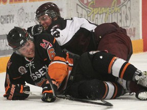 Tyler Raymont, left, of the Essex 73's is checked by Dresden's Cam Ross Tuesday at Essex Arena.   (DAN JANISSE/The Windsor Star)