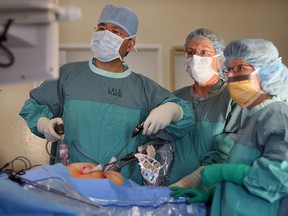 File photo of  Dr. Yigang Luo, left, and his assistant surgical nurses in the operating room at Hotel-Dieu Grace hospital in 2006. (Windsor Star files)