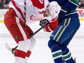 Detroit's Henrik Zetterberg, left, is checked by Vancouver's Kevin Bieksa at Rogers Arena in Vancouver. (Photo by Rich Lam/Getty Images)