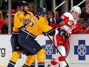 Justin Abdelkader #8 of the Detroit Red Wings tries to get to the puck next to Kevin Klein #8 and Scott Hannan #22 of the Nashville Predators during the first period at Joe Louis Arena on February 23, 2013 in Detroit, Michigan. (Photo by Gregory Shamus/Getty Images)