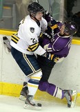 The University of Windsor's Drew Palmer, left, checks Western's Steve Reese at Windsor Arena. (TYLER BROWNBRIDGE/The Windsor Star)