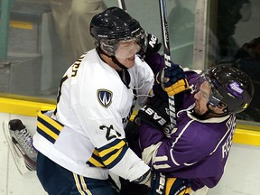 The University of Windsor's Drew Palmer, left, checks Western's Steve Reese at Windsor Arena. (TYLER BROWNBRIDGE/The Windsor Star)