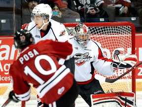 Spits goalie Jordan DeKort, right, makes a save on ex-Spit Saverio Posa Friday in Guelph. (Tony Saxon/Guelph Mercury)