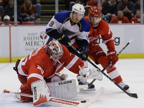 Detroit goalie Jimmy Howard, left, reaches for the puck in front of Jaden Schwartz of the Blues and Jakub Kindl  during the first period. (AP Photo/Carlos Osorio)