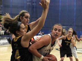 The University of Windsor's Jessica Clememcon, right, is defended by Waterloo's Jacqui Rodrigues, left, at the St. Denis Centre. (DAX MELMER/The Windsor Star)