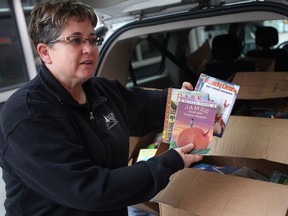 Kelly O'Rourke reveals the school books she found in a dumpster in front of the former St. Theresa Catholic School in Amhersburg, Ont., Monday, February 11, 2013.  O'Rourke filled her minivan with five boxes full of school books that she found in the dumpster.  (DAX MELMER/The Windsor Star)