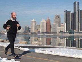 A jogger is pictured running along the Windsor's waterfront as the Detroit skyline is reflected on an undisturbed Detroit River, Monday, February 25, 2013.   (DAX MELMER/The Windsor Star)