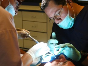 A dentist works on a patient. (Postmedia News files)