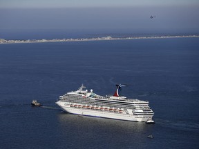 Disabled Carnival Lines cruise ship is towed toward the harbour off Mobile Bay, Ala., Feb. 14, 2013. (AP Photo/Gerald Herbert)