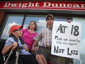 The Chauvin family, from left, Joseph, 17, who has cerebral palsy, his mother Cathy, and father Maurice, protest against budget cuts for families caring for family members with disabilities while outside MPP Dwight Duncan's Windsor office, Thursday, June 21, 2012.   (DAX MELMER/The Windsor Star)