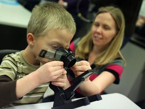 Caden Caravaggio looks through a microscope with his mother, Megan Caravggio, while in the mad science room at the University of Windsor Faculty of Education Family Fun Day at the Faculty of Education, Monday, February 18th, 2013.  Admission was by donation only, with funds going to the Children's Aid Foundation and Teachers for Tanzania.  Activities included fortune telling, face painting, mad science, drama games, and arts and crafts.  (DAX MELMER/The Windsor Star)