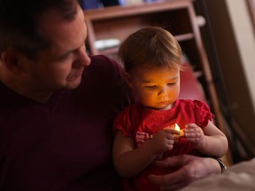 Jeff Barefoot watches as his daughter, Emmi Barefoot, 1, get her fortune read at the University of Windsor Family Fun Day Monday, February 18th, 2013.    (DAX MELMER/The Windsor Star)