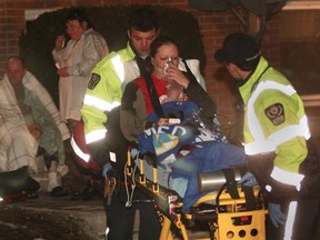 Paramedics transport a woman from the scene of an apartment fire in the 2700 block of Meadowbrook Lane.