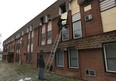 Employees with Promus Disaster Restoration Specialists board up an apartment unit Tuesday, Feb. 26, 2013, in the 6600 block of Thornberry Crescent in Windsor, Ont. A man died in the fire.   (DAN JANISSE/The Windsor Star)