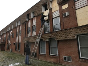 Employees with Promus Disaster Restoration Specialists board up an apartment unit Tuesday, Feb. 26, 2013, in the 6600 block of Thornberry Crescent in Windsor, Ont. A man died in the fire.   (DAN JANISSE/The Windsor Star)