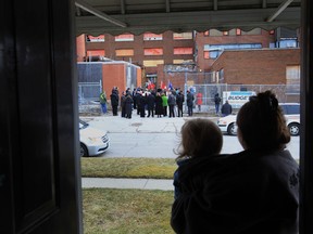 Phyllis Beedle and her 18 month-old grandson Donald Beaton look out from Beedle's Oak Avenue home as a press conference is held at the old Grace Hospital site in Windsor, Ontario on February 15, 2013.  An announcement was made by MPP Windsor-West, Teresa Piruzza and Windsor Mayor Eddie Francis, that the province has provided $3 million for demolition and an additional $4 million that is still awaiting government approval.  (JASON KRYK/The Windsor Star)